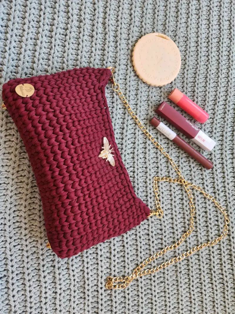 Cartera tejida burdeo con cadena dorada